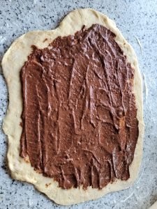 Die Wallnuss-Füllung wird auf dem Teig verteilt und eingerollt