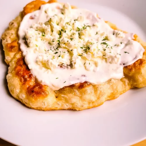 Langos Rezept_Langos mit Sauerrahm und Käse servieren