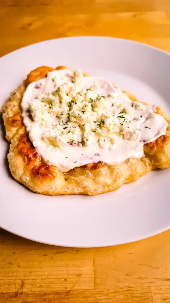 Langos Rezept_Langos mit Sauerrahm und Käse servieren